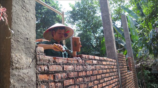 Lu Van Huynh in Bao Ha commune, Bao Yen district is donated 100 million VND to rebuild his house after the typhoon. VNA Photo: Hương Thu 
