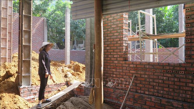 Lu Van Huynh in Bao Ha commune, Bao Yen district receives a financial donation of 100 million VND to rebuild his house. VNA Photo: Hương Thu 