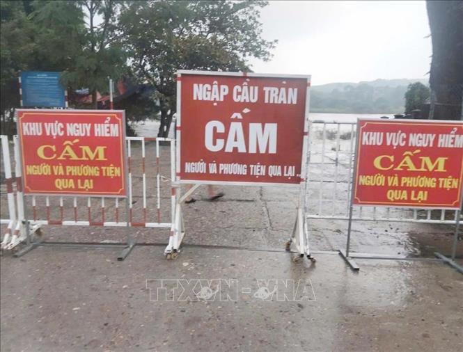 Cơ quan chức năng cấm người và phương tiện qua lại qua cầu tràn Thạch Nham do ngập nước. Ảnh: Phạm Cường-TTXVN