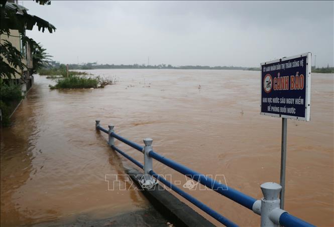 Thị trấn Sông Vệ, huyện Tư Nghĩa cấm người dân đi qua khu vực ngập nước. Ảnh: Phạm Cường-TTXVN