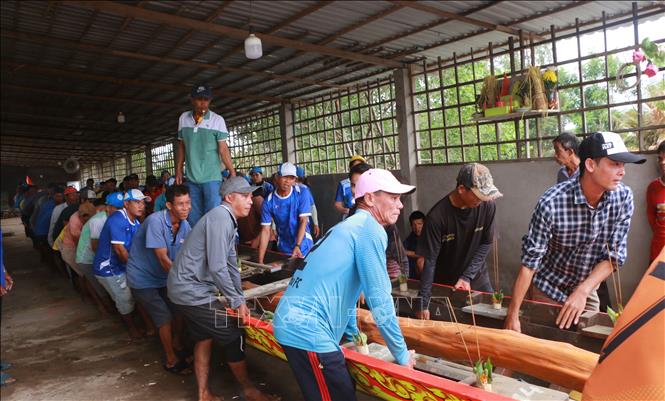 Di chuyển ghe Ngo xuống nước để làm lễ hạ thủy. Ảnh: Tuấn Phi - TTXVN