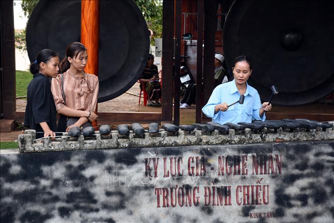 Khách du lịch trải nghiệm đánh đàn đá tại Khu Bảo tồn Văn hóa dân tộc S'tiêng sóc Bom Bo, huyện Bù Đăng, tỉnh Bình Phước. Ảnh: Nhật Bình - TTXVN