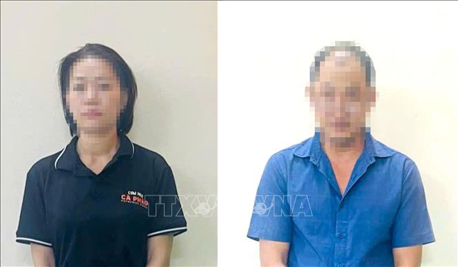 Hai đối tượng Lê Văn Hòa (phải) và Nguyễn Thị Kim Trang, nhân viên tiệm vàng Đức Long, quận Tân Bình (Thành phố Hồ Chí Minh). Ảnh: TTXVN phát
