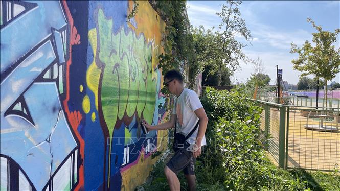 Họa sĩ Meuh, một chuyên gia vẽ tranh graffiti, sáng tạo tác phẩm của mình trên đường phố.  Ảnh: Thu Hà - P/v TTXVN tại Pháp