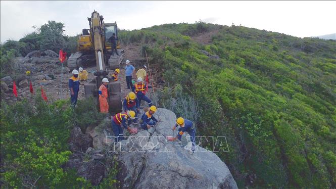 Công nhân khoan khối đá trên đèo Cù Hin. Ảnh: Đặng Tuấn -TTXVN