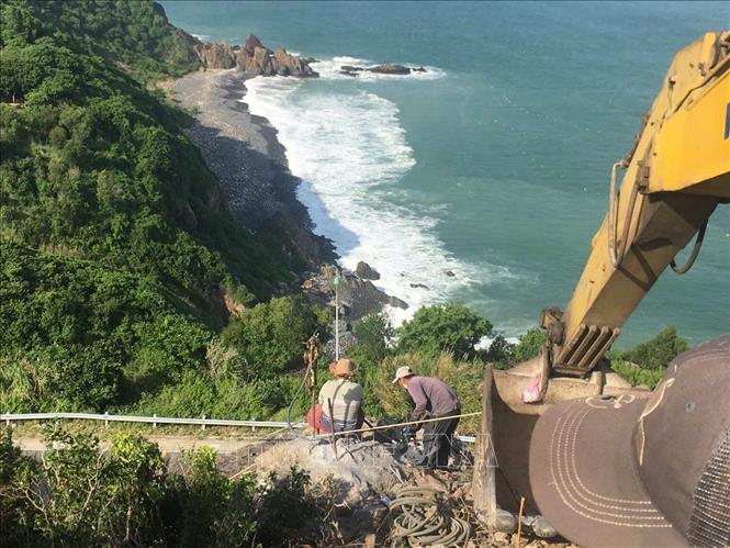 Lực lượng chức năng tiến hành khoan khối đá nằm trên đỉnh đèo Cù Hin. Ảnh: Đặng Tuấn -TTXVN