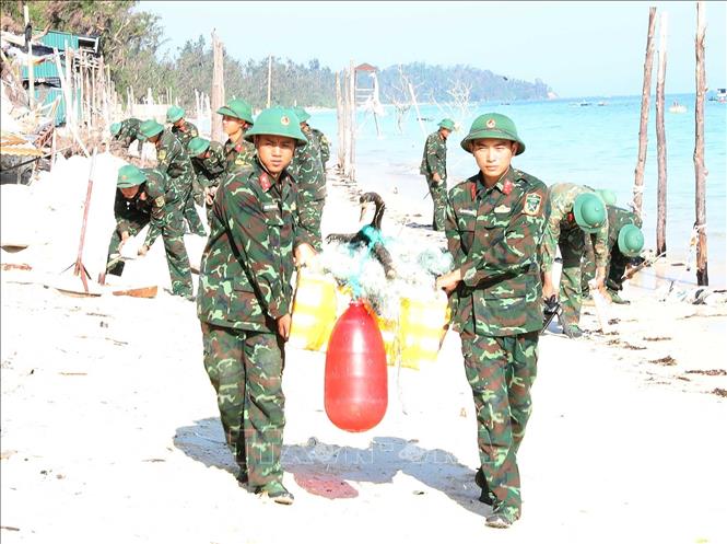 Chiến sĩ Tiểu đoàn Cô Tô dọn dẹp, vệ sinh môi trường bãi biển xã Đồng Tiến trả lại cảnh quan để phát triển du lịch. Ảnh: Trọng Đức - TTXVN