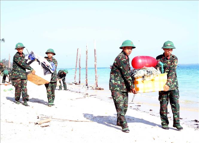 Chiến sĩ Tiểu đoàn Cô Tô dọn dẹp, vệ sinh môi trường bãi biển xã Đồng Tiến trả lại cảnh quan để phát triển du lịch. Ảnh: Trọng Đức - TTXVN
