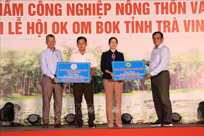 Ban Tổ chức tiếp nhận bảng tượng trưng hỗ trợ gạo cho hộ nghèo từ các nhà hảo tâm. Ảnh: Thanh Hòa- TTXVN