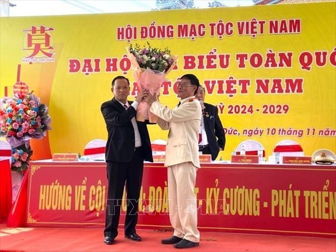 Ông Thái Khắc Việt, nguyên Chủ tịch Mạc tộc Việt Nam tặng hoa Thiếu tướng Phạm Quốc Huỳnh, Chủ tịch Hội đồng Mạc tộc Việt Nam khoá IV. Ảnh: Nguyễn Văn Cảnh -TTXVN