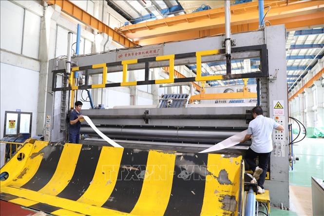 Các kỹ sư của Công ty Cổ phần Giấy HKB - Hoa Lư kiểm tra máy móc trước khi vào sản xuất mã sản phẩm mới. Ảnh: Đức Phương - TTXVN