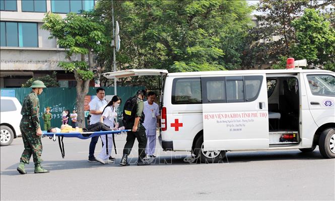 Các lực lượng chức năng kịp thời sơ cấp cứu người bị thương trong vụ cháy. Ảnh: Tạ Toàn – TTXVN