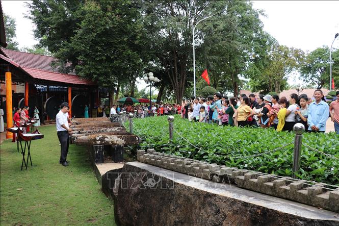 Du khách thưởng thức đàn đá do các nghệ nhận người S’tiêng biểu diễn tại Khu Bảo tồn Văn hóa dân tộc S’tiêng sóc Bom Bo. Ảnh: Nhật Bình – TTXVN