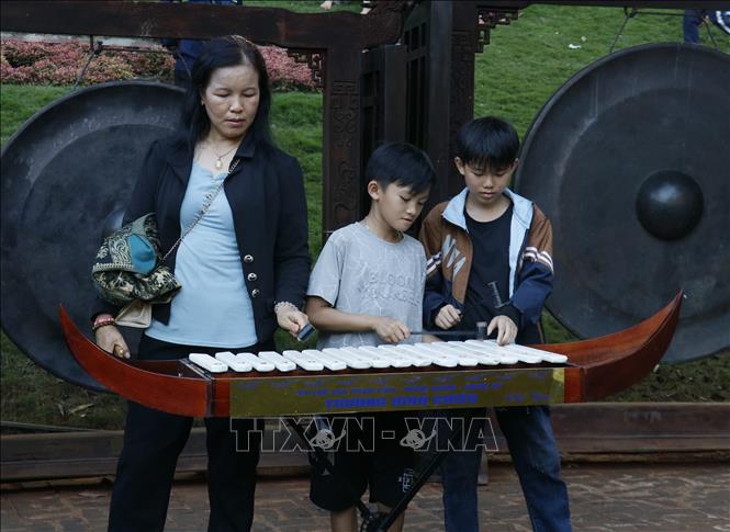 Khách tham quan trải nghiệm đánh đàn đá tại Khu Bảo tồn Văn hóa dân tộc S’tiêng sóc Bom Bo. Ảnh: Nhật Bình – TTXVN