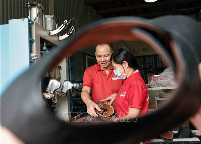 Công nhân hoàn thiện đế giầy tại Công ty giầy Việt Anh. Ảnh: Trần Việt - TTXVN