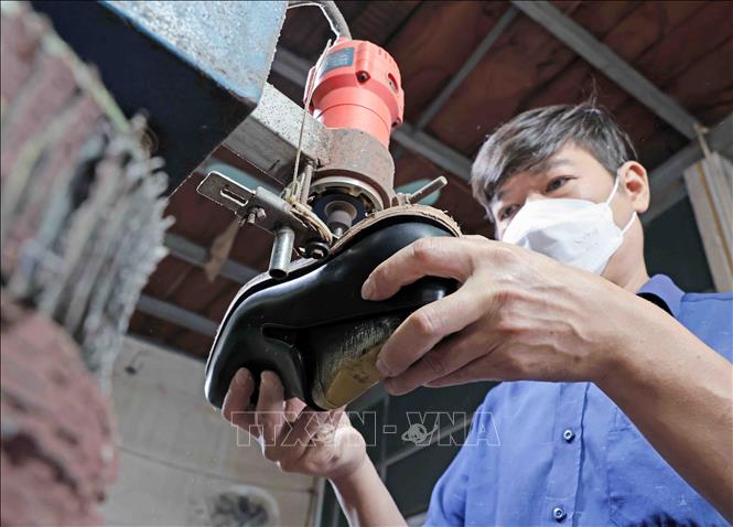 Hoàn thiện đế giầy tại Công ty giầy Việt Anh. Ảnh: Trần Việt - TTXVN