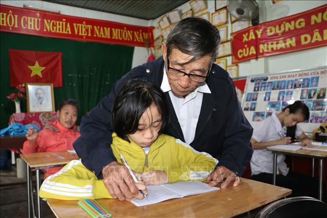 Dù tuổi cao, sức yếu nhưng thầy vẫn luôn miệt mài dạy dỗ, nắn từng nét chữ cho học sinh khuyết tật. Ảnh: Đinh Hương - TTXVN