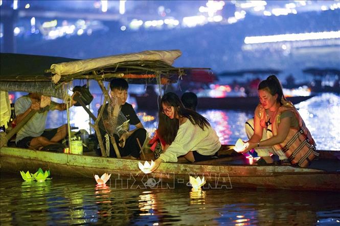 Các bạn trẻ thích thú tham gia thả hoa đăng trên sông. Ảnh: Trọng Đạt-TTXVN