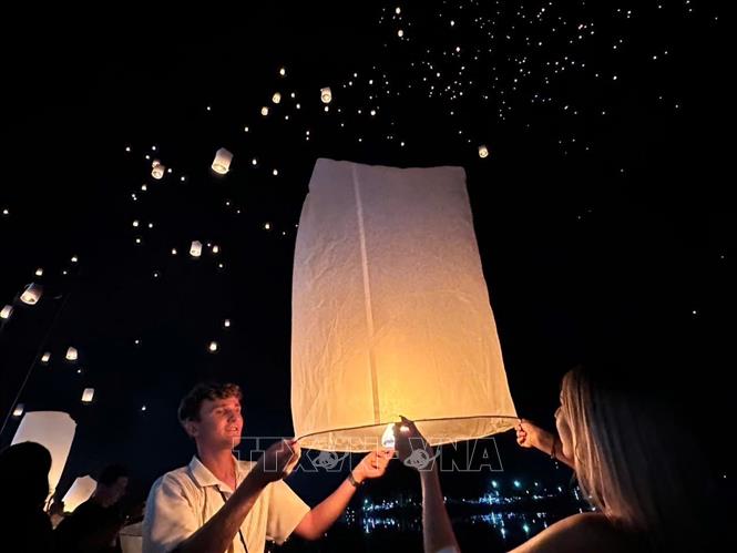 Du khách quốc tế thích thú tham gia lễ hội. Ảnh: TTXVN phát