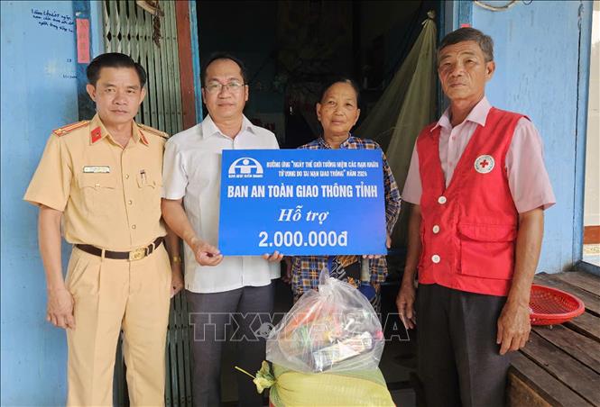 Ông Phạm Thống Nhất (thứ hai từ trái qua), Chánh Văn phòng Ban An toàn giao thông tỉnh tặng quà gia đình bà Thị Vân, ấp An Phú, xã Vĩnh Phước B, huyện Gò Quao có con bị tai nạn giao thông tử vong. Ảnh: Lê Sen - TTXVN