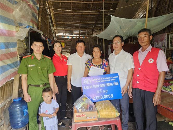Ông Phạm Thống Nhất (thứ hai, từ phải qua), Chánh Văn phòng Ban An toàn giao thông tỉnh thăm hỏi, động viên và tặng quà gia đình bà Nguyễn Hoàng Anh, ngụ ấp An Trung, xã Định An, huyện Gò Quao có con bị tai nạn giao thông. Ảnh: Lê Sen - TTXVN