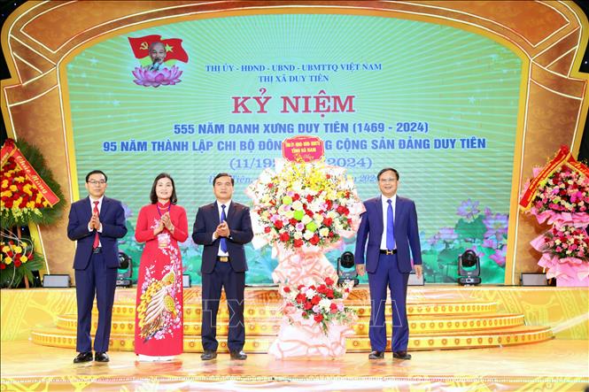 Lãnh đạo tỉnh Hà Nam tặng hoa cho Đảng bộ, chính quyền, quân và dân Thị xã Duy Tiên (Hà Nam) tại lễ kỷ niệm. Ảnh: Đại Nghĩa - TTXVN