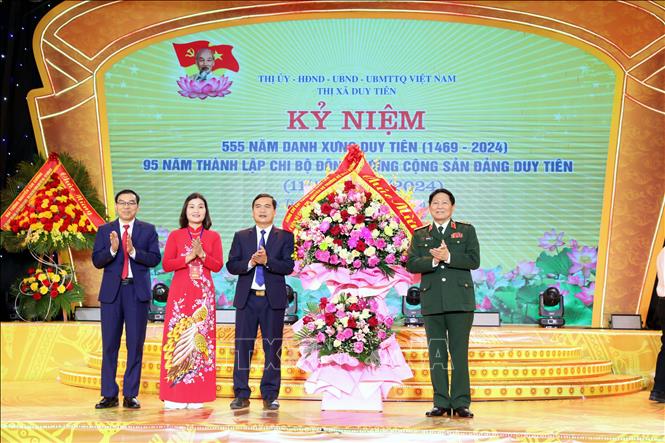 Các đại biểu Đảng và Nhà nước tặng hoa cho Đảng bộ, chính quyền, quân và dân Thị xã Duy Tiên (Hà Nam) tại lễ kỷ niệm. Ảnh: Đại Nghĩa - TTXVN