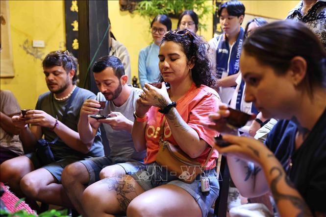 Các du khách nước ngoài thưởng thức trà tại Ngôi nhà di sản. Ảnh: Minh Đức – TTXVN