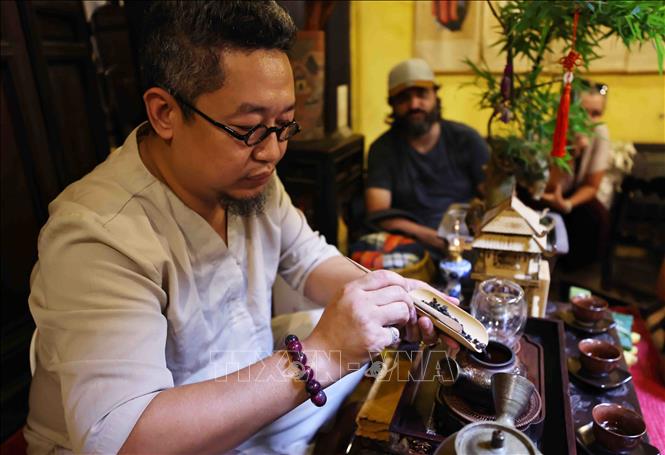 Nghệ nhân trà Nguyễn Cao Sơn trình diễn pha trà. Ảnh: Minh Đức – TTXVN