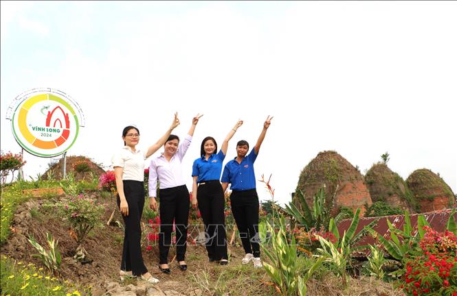 Khách tham quan chụp ảnh bên những mái lò gạch tại Làng nghề sản xuất gạch gốm huyện Mang Thít, tỉnh Vĩnh Long. Ảnh: Lê Thúy Hằng - TTXVN