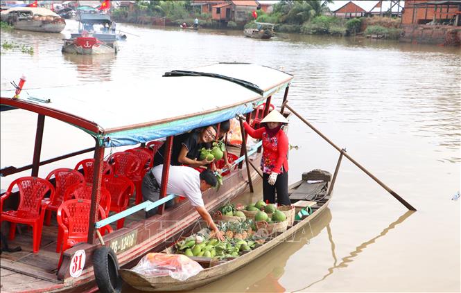 Du khách trải nghiệm không gian Trên bến dưới thuyền tại kênh Thầy Cai, huyện Mang Thít, tỉnh Vĩnh Long. Ảnh: Lê Thúy Hằng - TTXVN