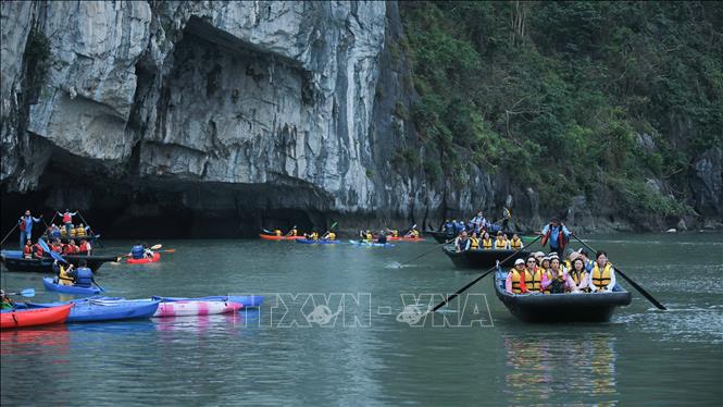 Du khách nước ngoài đến tham quan hang Luồn trên vịnh Hạ Long. Ảnh: Hoàng Hiếu – TTXVN