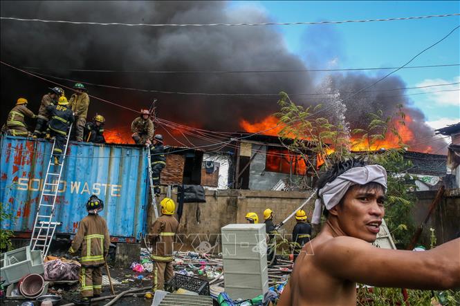 Lính cứu hỏa nỗ lực dập đám cháy tại khu ổ chuột ở thủ đô Manila, Philippines ngày 24/11/2024. Ảnh: THX/TTXVN