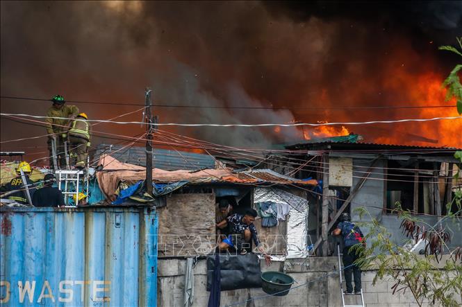 Lính cứu hỏa nỗ lực dập đám cháy tại khu ổ chuột ở thủ đô Manila, Philippines ngày 24/11/2024. Ảnh: THX/TTXVN