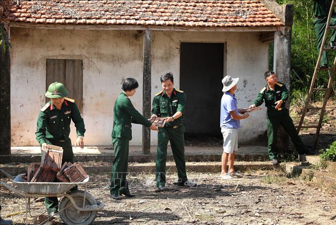 Cán bộ, chiến sỹ Ban Chỉ huy Quân sự huyện Yên Thế giúp sửa chữa nhà cho gia đình bà Nguyễn Thị Sứ tại bản Cầu Nhãn, xã Xuân Lương. Ảnh: Danh Lam - TTXVN 
