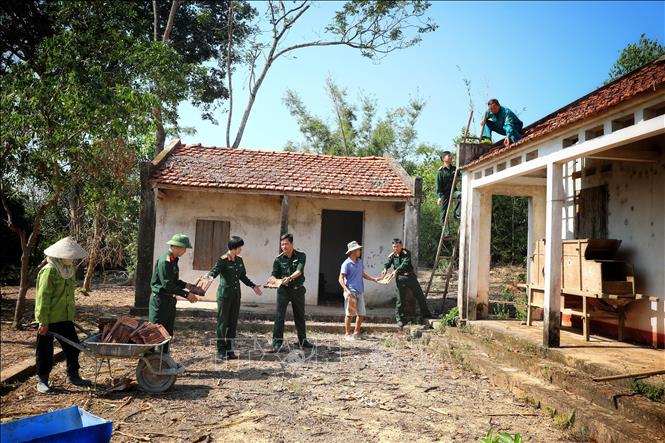 Cán bộ, chiến sỹ Ban Chỉ huy Quân sự huyện Yên Thế giúp sửa chữa nhà cho gia đình bà Nguyễn Thị Sứ tại bản Cầu Nhãn, xã Xuân Lương. Ảnh: Danh Lam TTXVN 