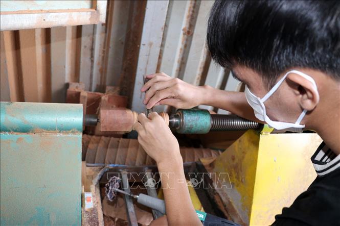 Hầu hết thợ ở làng nghề tủ thờ Gò Công đều đã áp dụng máy móc hiện đại vào sản xuất. Ảnh: Hữu Chí – TTXVN