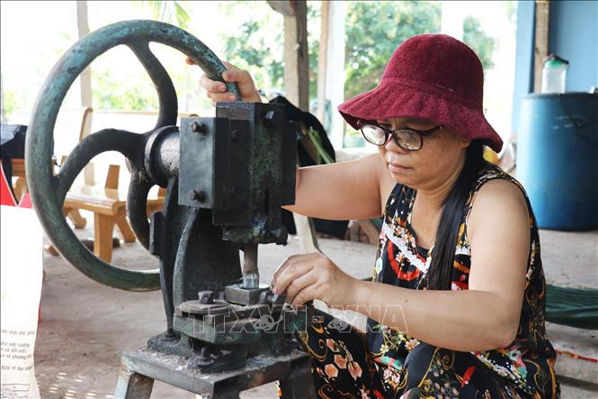 Công đoạn tạo hình trên vỏ ốc xà cừ để khảm vào tủ thờ Gò Công. Ảnh: Hữu Chí – TTXVN