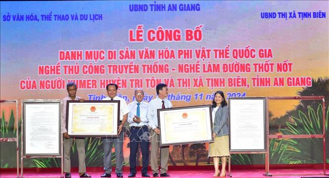 Phó Giám đốc Sở Văn hóa, Thể thao và Du lịch tỉnh An Giang Trương Bá Trang (thứ 3, trái) trao Quyết định của Bộ trưởng Bộ Văn hóa, Thể thao và Du lịch công nhận nghề làm đường thốt nốt của đồng bào dân tộc thiểu số Khmer huyện Tri Tôn và thị xã Tịnh Biên (tỉnh An Giang) là di sản văn hóa phi vật thể quốc gia. Ảnh: Công Mạo-TTXVN