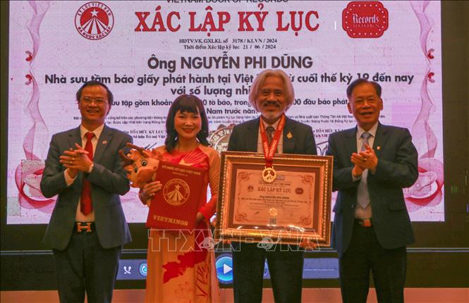 Tổ chức kỷ lục Việt Nam trao chứng nhận xác lập kỷ lục cho ông Nguyễn Phi Dũng, nhà sưu tầm báo giấy phát hành tại Việt Nam từ cuối thế kỷ 19 đến nay với số lượng nhiều nhất. Ảnh: Công Luật - TTXVN