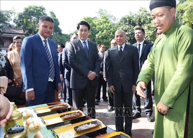 Cambodian King Preah Bat Samdech Preah Boromneath Norodom Sihamoni and State President Luong Cuong learn about various types of Vietnamese tea at the Temple of Literature. VNA Photo 