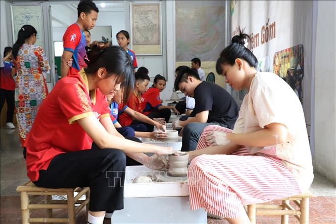 Khách trải nghiệm hoạt động xoay gốm. Ảnh: Lê Xuân - TTXVN