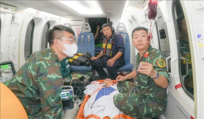Tổ cấp cứu đường không Bệnh viện Quân y 175 theo dõi, chăm sóc người bệnh trong quá trình vận chuyển. Ảnh: TTXVN phát 