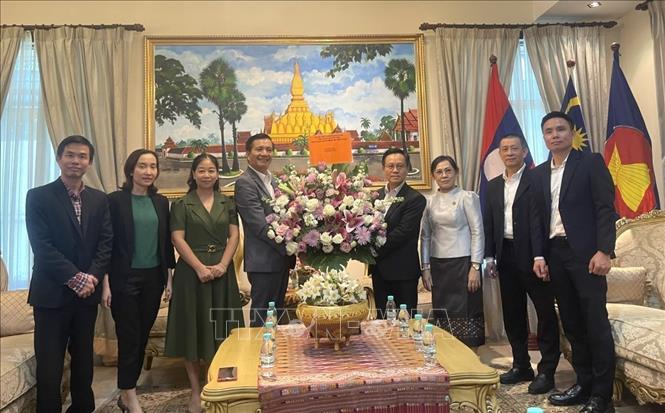 Đại sứ Việt Nam tại Malaysia Đinh Ngọc Linh (thứ 4, bên trái) tặng hoa cán bộ, nhân viên Đại sứ quán Lào. (Ảnh: Thành Trung - TTXVN)