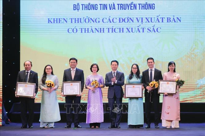 Bộ trưởng Bộ Thông tin và Truyền thông Nguyễn Mạnh Hùng trao tặng Bằng khen của Bộ trưởng cho các đơn vị xuất bản có thành tích xuất sắc. Ảnh: Minh Quyết - TTXVN