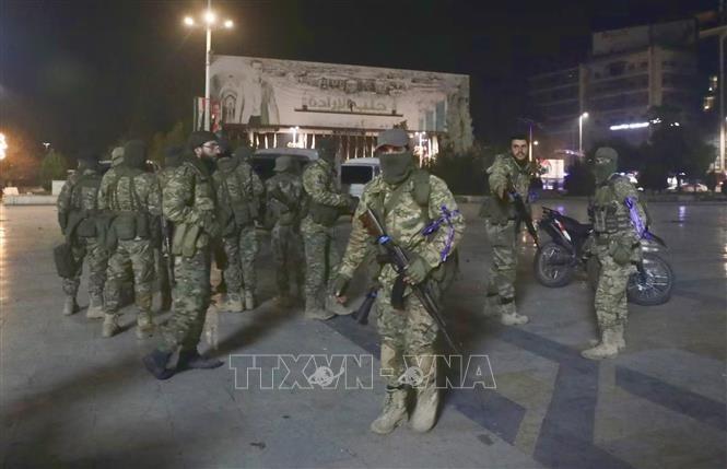Các tay súng phiến quân Syria trên quảng trường Saadallah al-Jabiri sau khi chiếm giữ được thành phố Alleppo, ngày 30/11/2024. Ảnh: REUTERS/TTXVN
