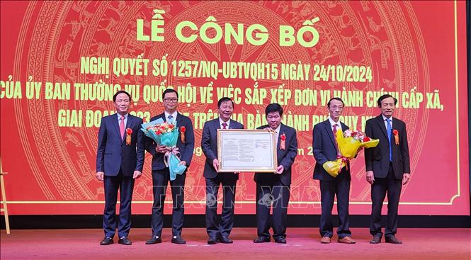 Lãnh đạo tỉnh Bình Định trao Nghị quyết của Thường vụ Quốc hội cho lãnh đạo thành phố Quy Nhơn. Ảnh: Sỹ Thắng - TTXVN