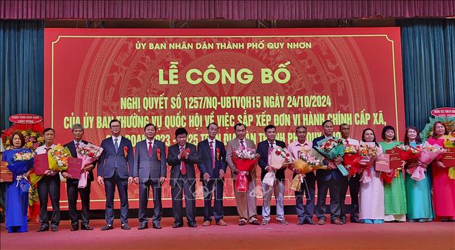 Lãnh đạo thành phố Quy Nhơn trao quyết định và tặng hoa cho các chủ tịch, bí thư phường mới. Ảnh: Sỹ Thắng - TTXVN