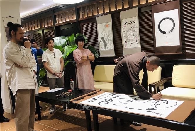 Khách mời tham gia vẽ tranh thư pháp tại sự kiện. Ảnh: Phương Lan - TTXVN 