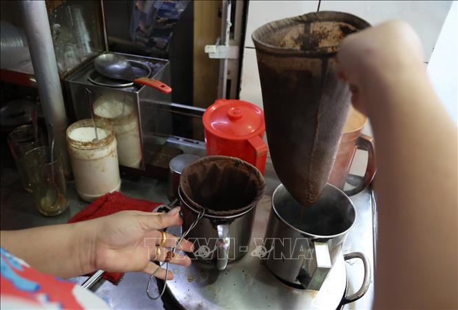 Chủ quán sử dụng 2 chiếc vợt để pha cà phê liên tục, đảm bảo có cà phê nóng hổi phục vụ khách. Ảnh: Hồng Đạt - TTXVN 